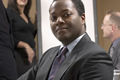 man in business suit sitting and smiling confidently